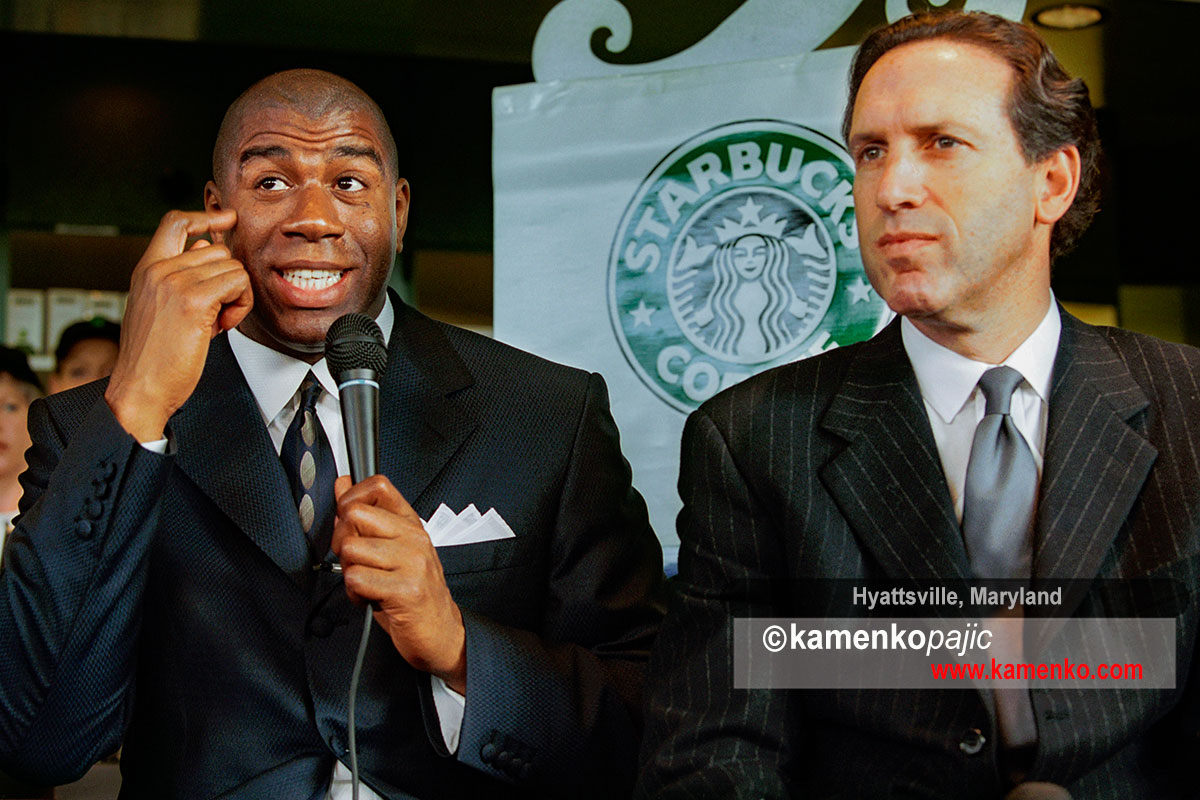 Howard Schultz, chairman and CEO of Starbucks Coffee Company(right) listen to NBA great, Earvin 