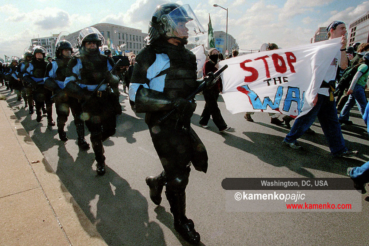 Police officers follow demonstrators during a rally against the World Bank and the International Monetary Fund in Washington