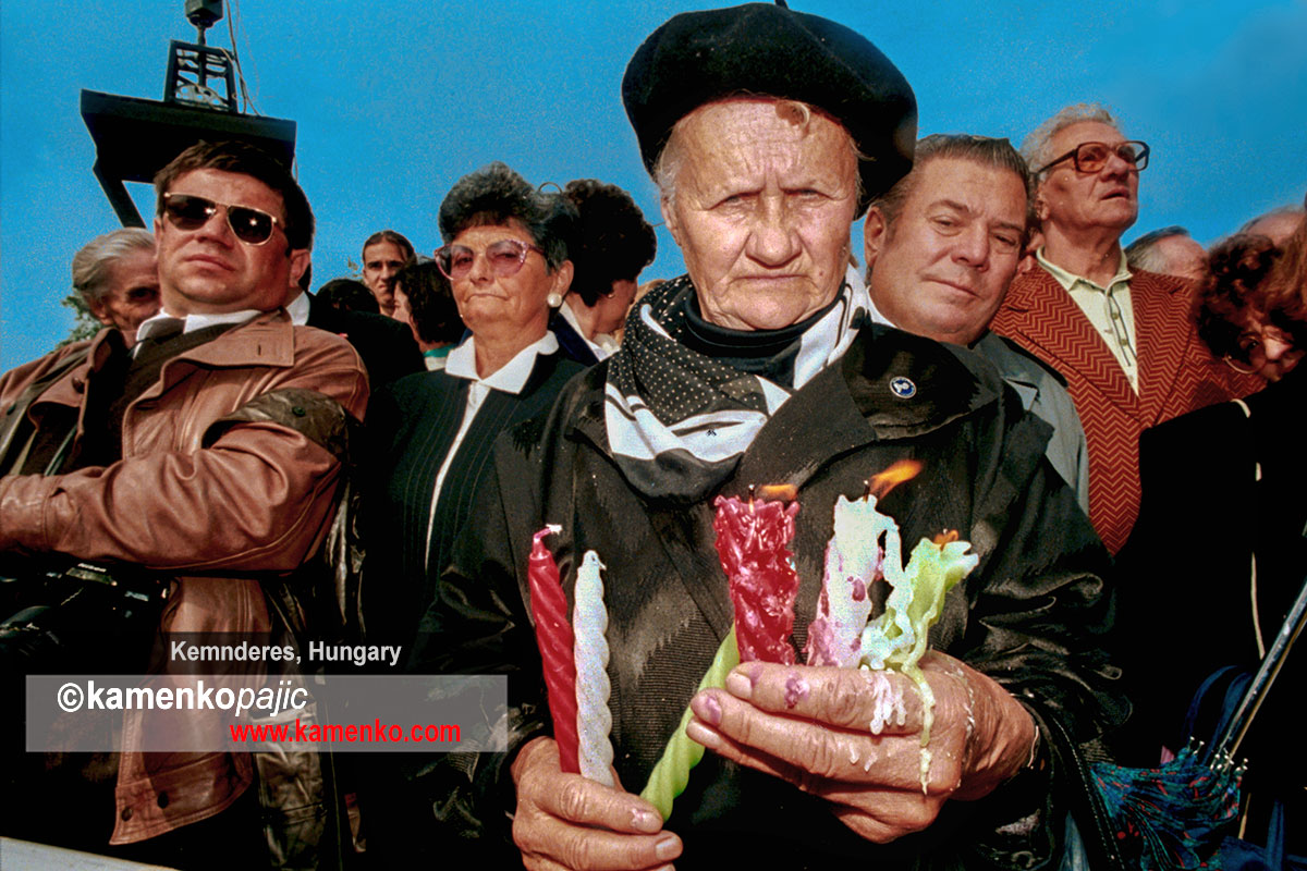 Elderly woman holds candles in the color of the Hungarian flag